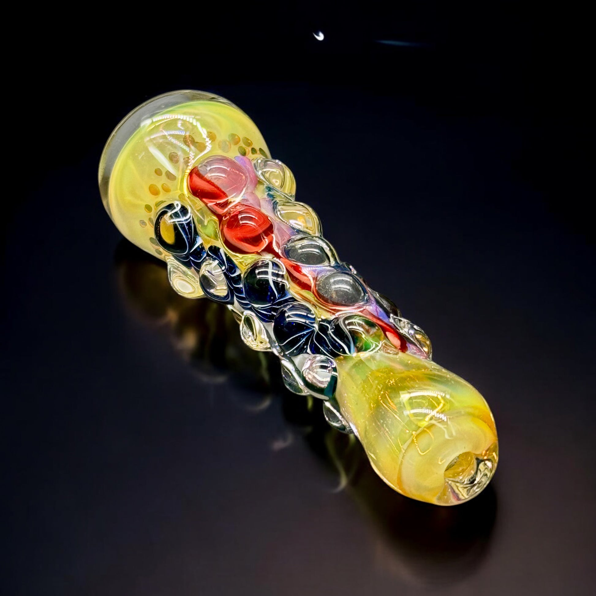 Unique artisan chillum glass pipe with heavy dot texture and red-yellow fumed base