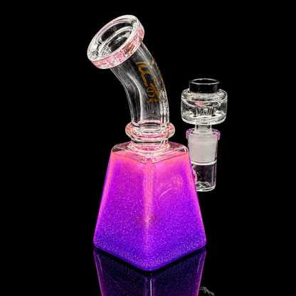 Glass smoking device with purple glitter base on a black background