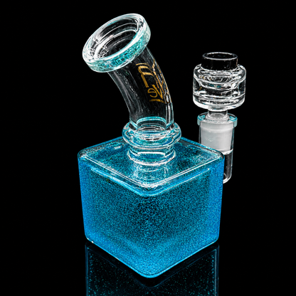 Glass water pipe with blue glittery base on a black background