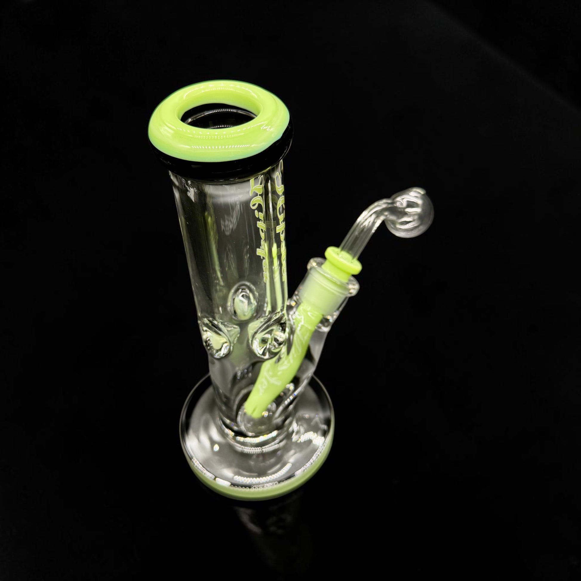 Glass smoking device with green accents on a black background
