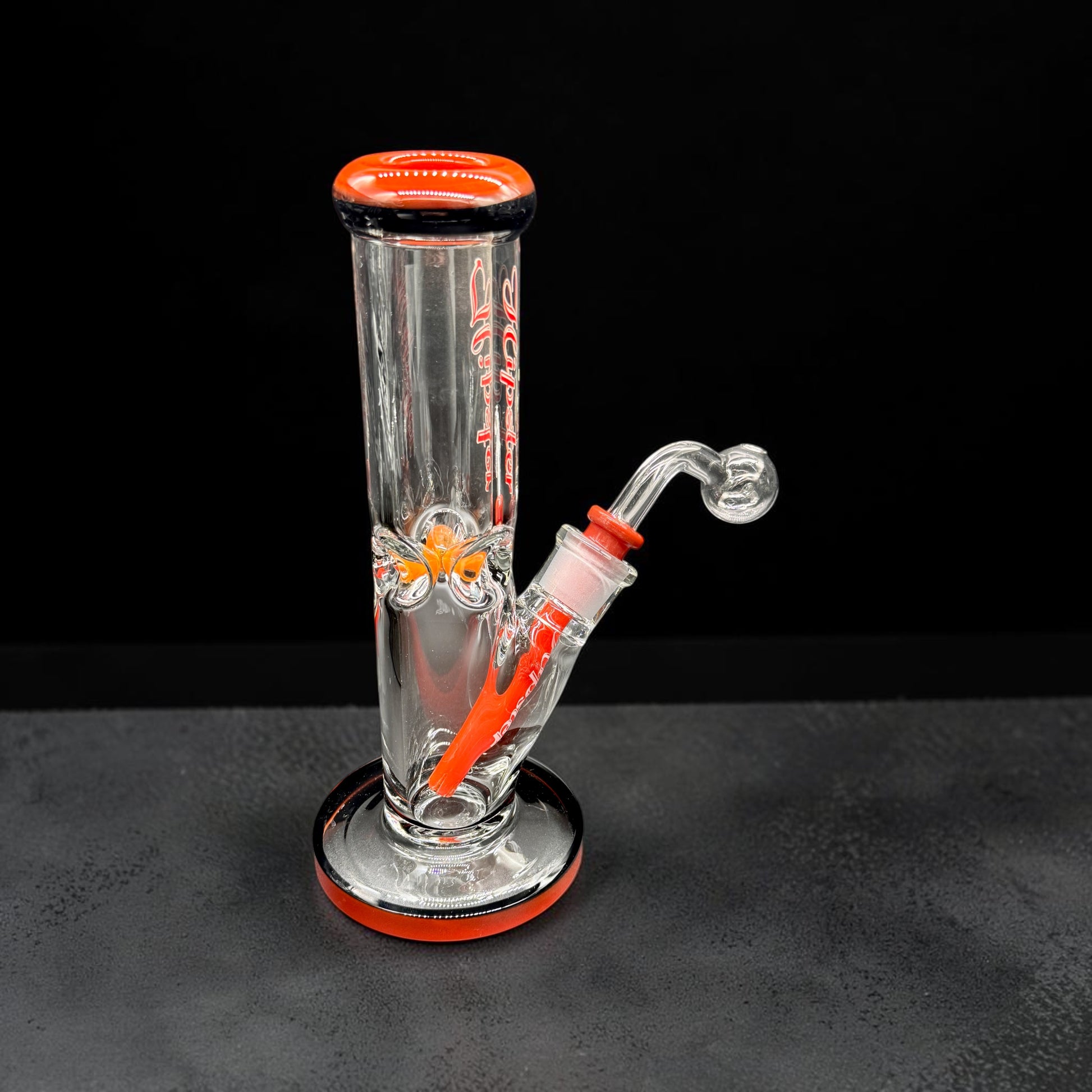 Glass water pipe with red accents on a black background