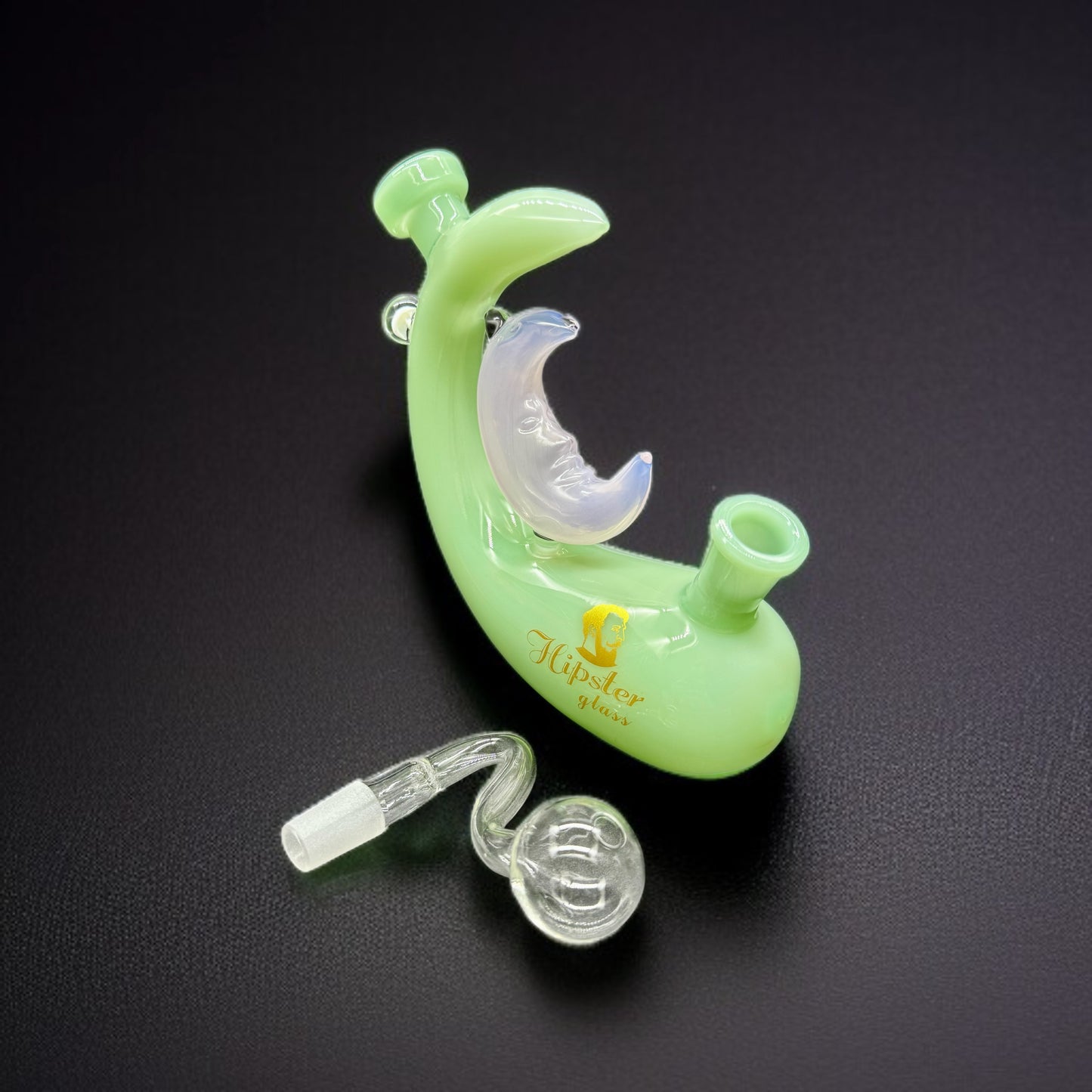 Green glass smoking device with clear components on a black background