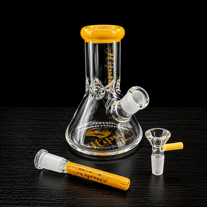 Glass smoking device with yellow accents on a dark surface