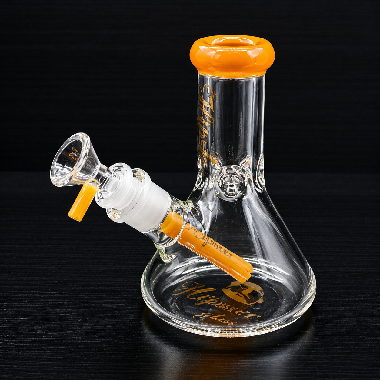 Glass water pipe with orange accents on a black background