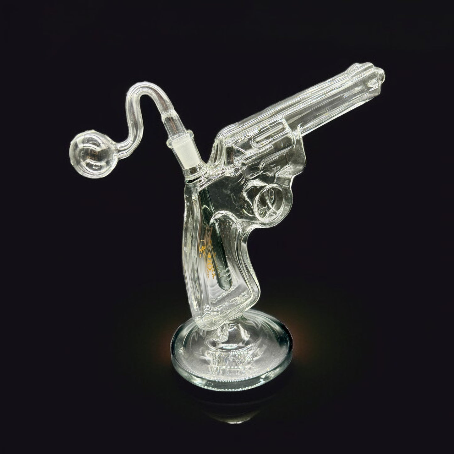 Clear glass smoking accessory shaped like a revolver on a black background