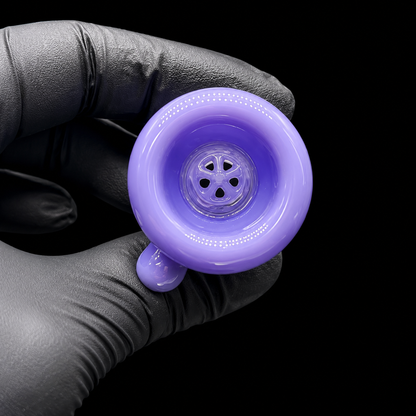 Purple glass pipe held by a gloved hand against a black background