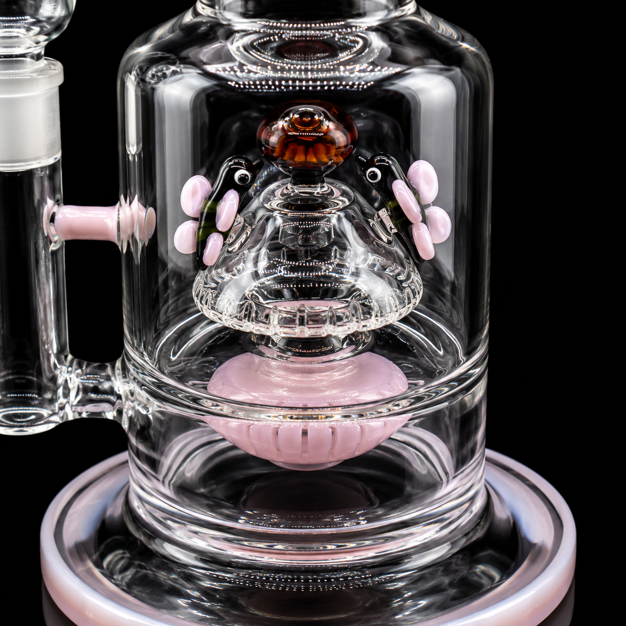 Glass smoking device with pink accents on a black background