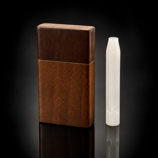 A dark brown wooden vape case standing upright next to a translucent white vape pen, set against a dark reflective studio background.