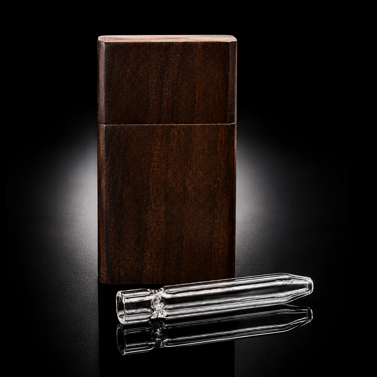 A dark brown wooden rectangular case stands upright on a glossy black surface, with a clear glass mouthpiece placed horizontally in front of it.