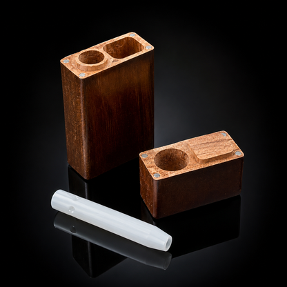 Two rectangular wooden smoking accessories with circular cutouts, shown on a glossy black reflective surface, alongside a translucent white mouthpiece.