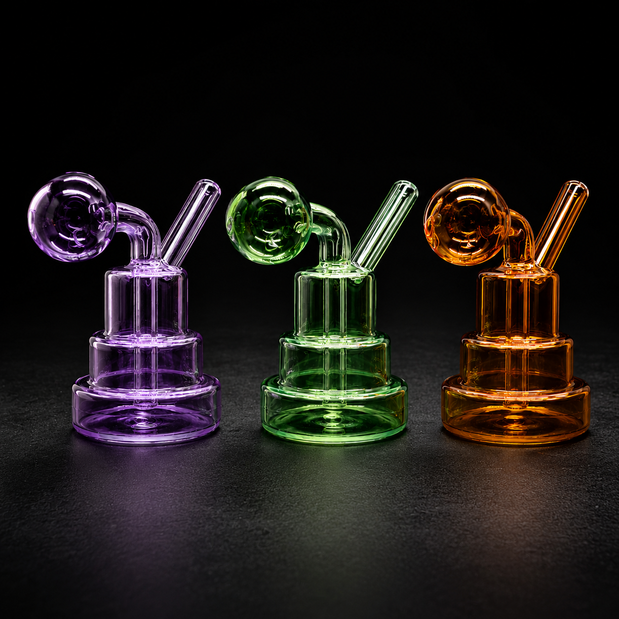 Three glass smoking devices in purple, green, and orange on a black background