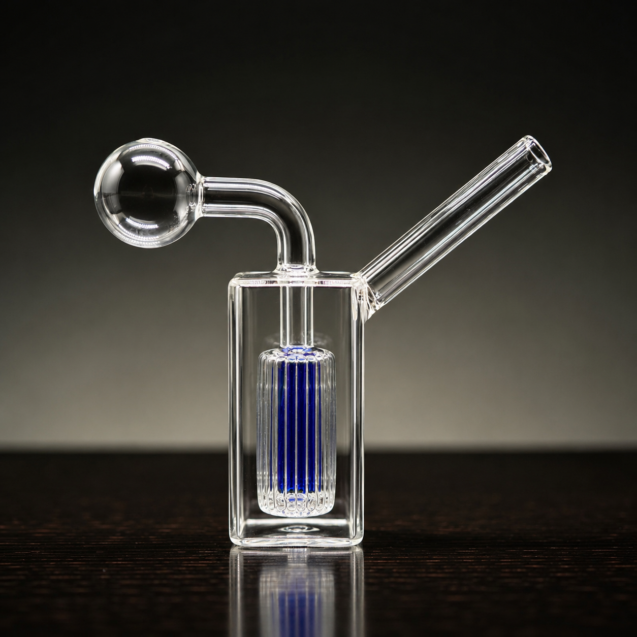 Clear glass smoking device with blue filter on a dark background