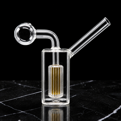 Clear glass smoking device with a metallic accent on a black marble surface