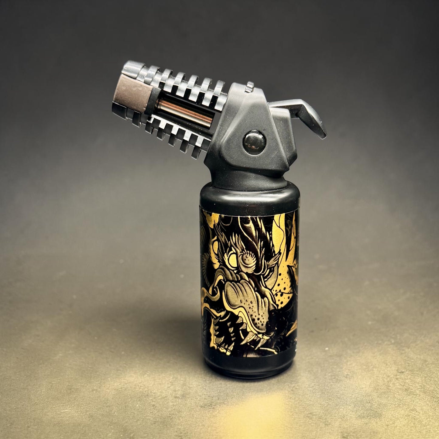 Butane lighter with dragon design on a dark background