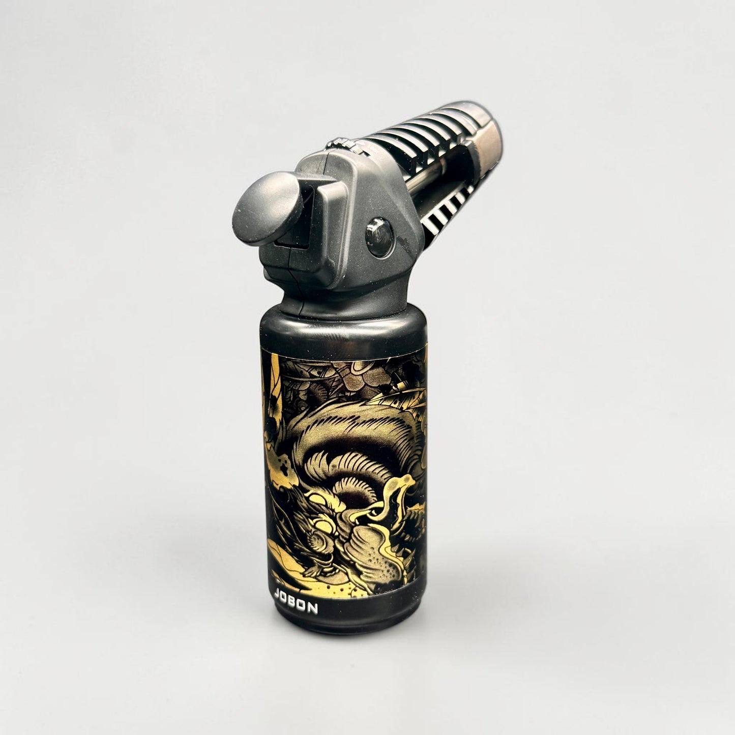 Butane lighter with gold dragon design on a white background