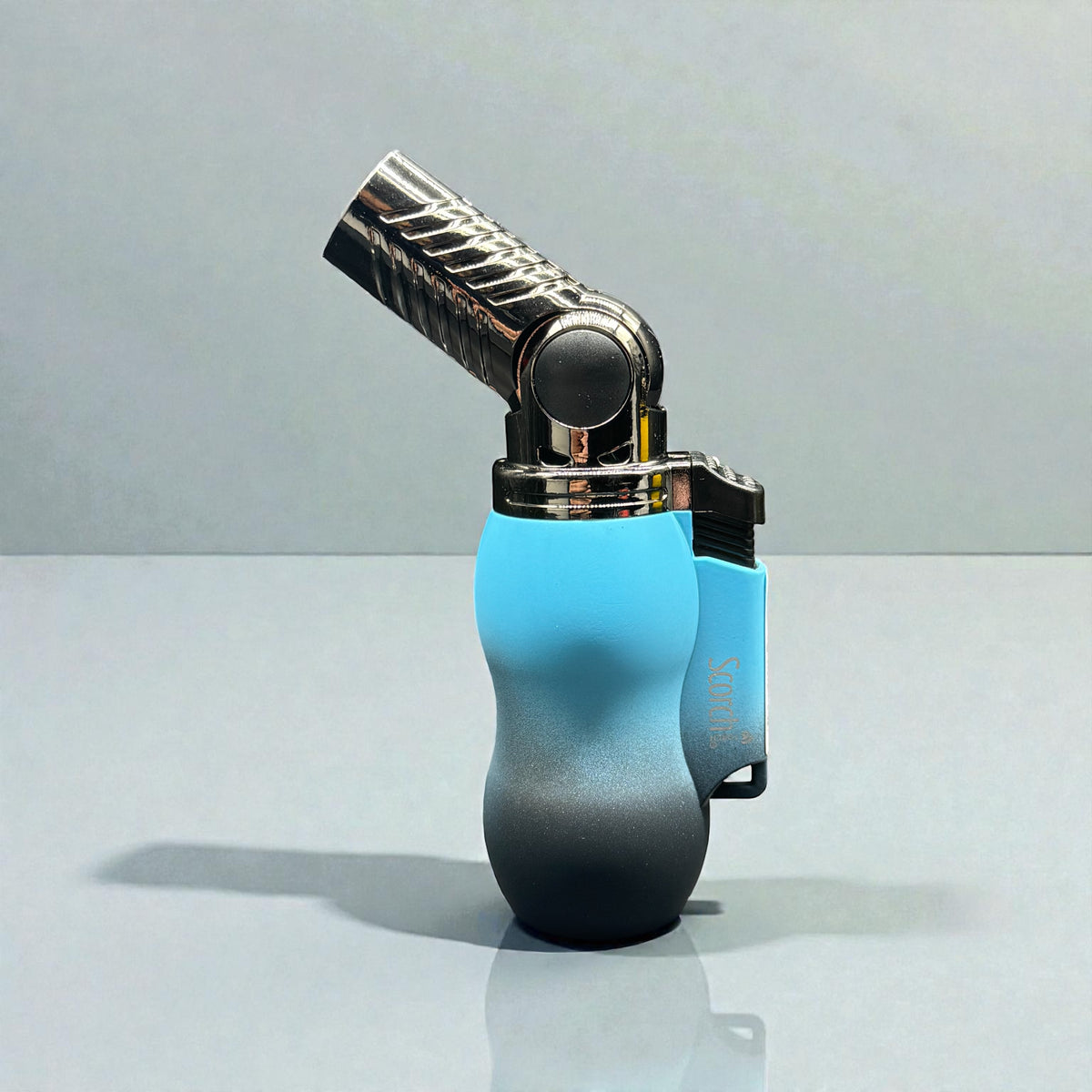 A modern lighter with a metallic silver flame tip and a body featuring a blue-to-black gradient, set against a clean gray studio background.