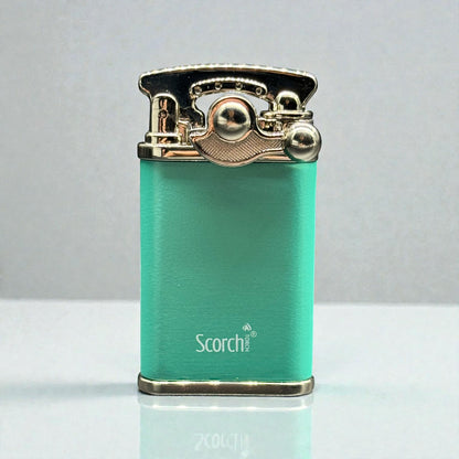 A turquoise green portable lighter with polished gold-toned metal accents and the brand name 'Scorch' printed on the front, set against a neutral gray background.