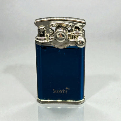 A blue metallic Scorch lighter with a polished silver-toned lighter mechanism on top, standing upright on a light gray reflective surface.