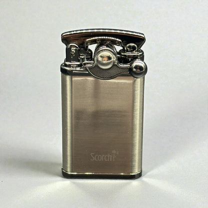 A brushed metal lighter with a polished chrome top mechanism, featuring the 'Scorch+' brand name printed near the bottom, set against a plain light gray background.