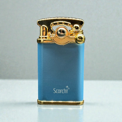 A blue metallic lighter with a gold-toned top mechanism and base, featuring the 'Scorch' brand name printed in white on the front, set against a neutral gray background.