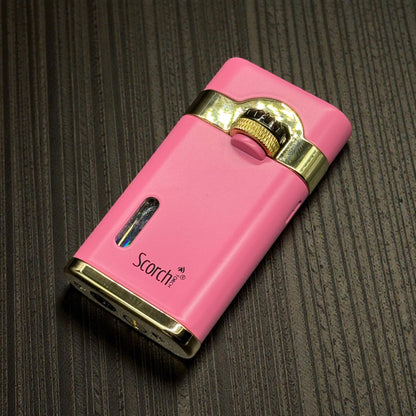 A pink portable electric lighter with gold trim and the 'Scotch' brand name printed on the side, resting on a dark textured surface.
