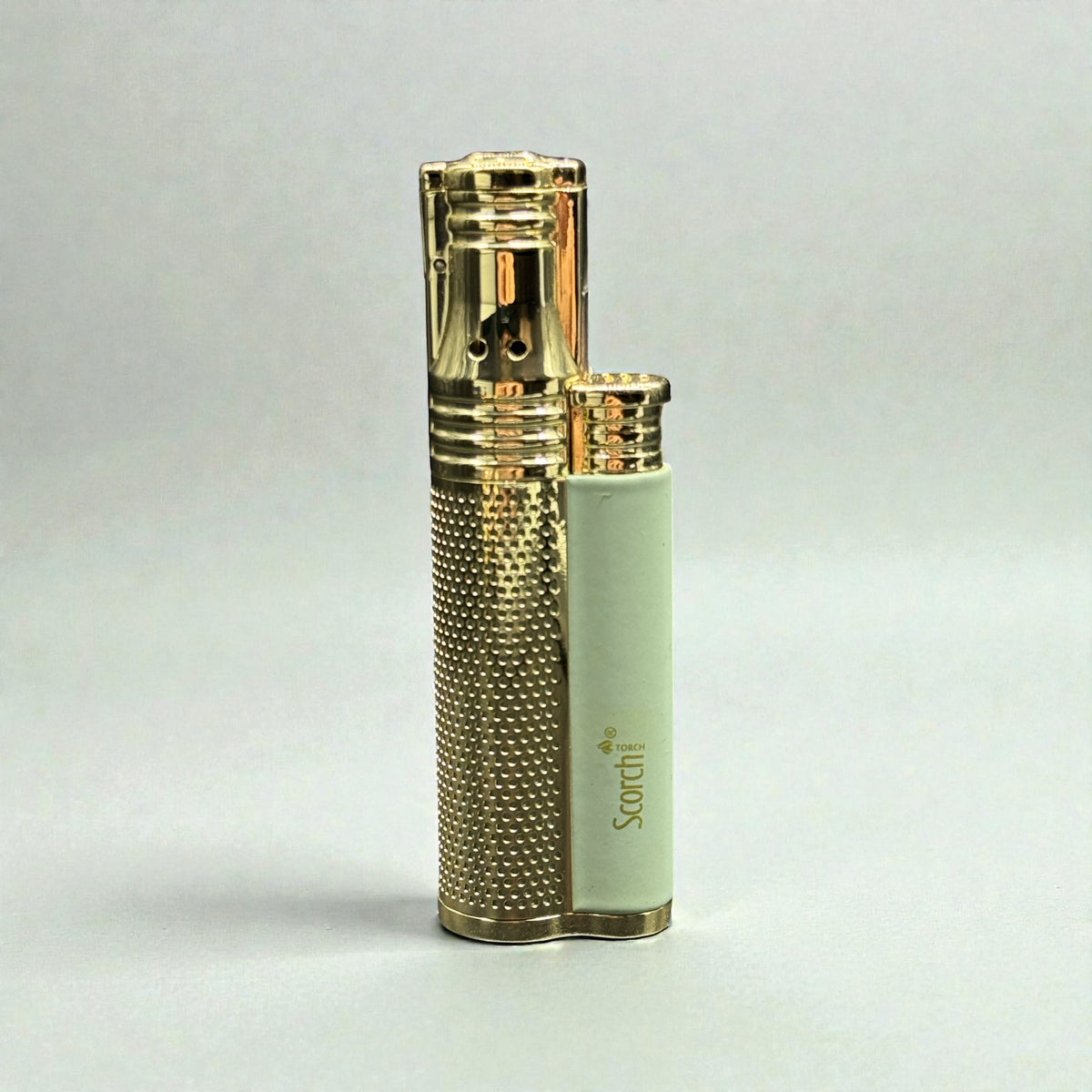 A luxury double lighter with a textured gold metallic body and a pale mint green side panel featuring the 'Sourrit' brand logo, set against a neutral light gray background.