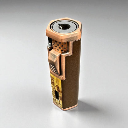 Bronze-colored lighter with intricate design on a gray background
