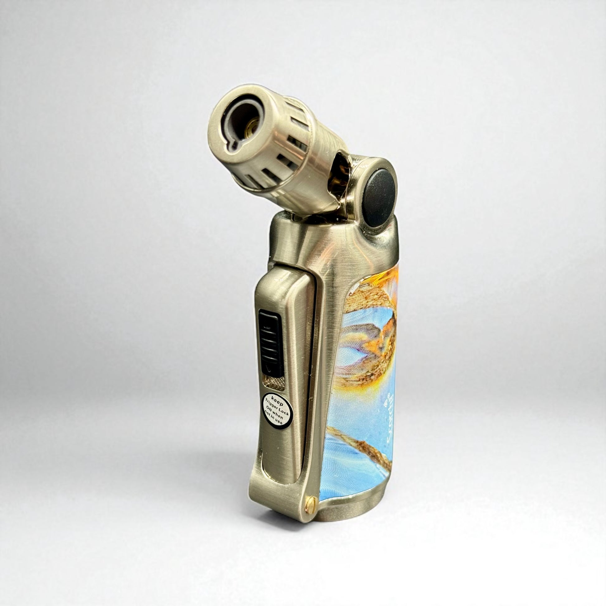 Gold lighter with a scenic design on a white background