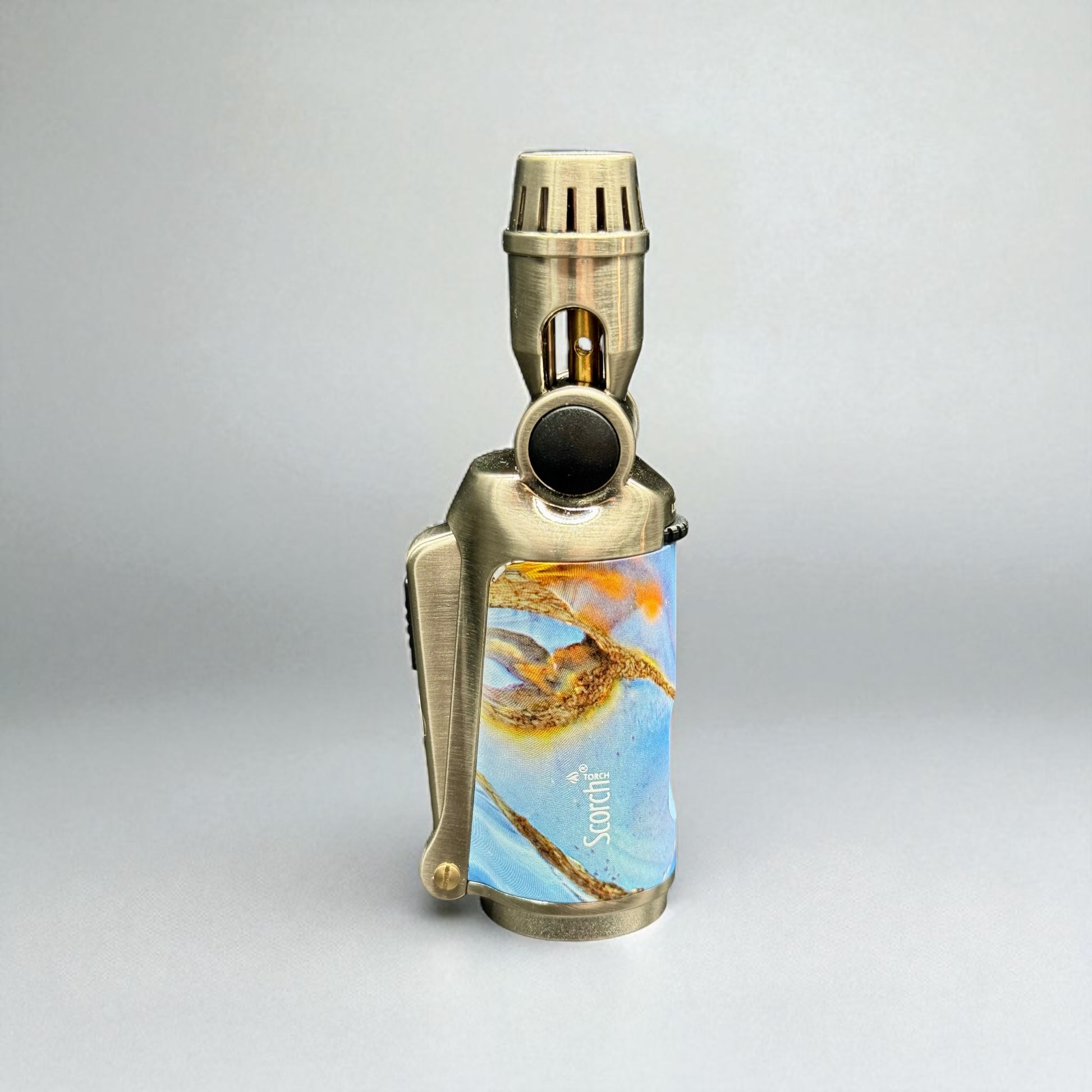 Brass lighter with a colorful design on a gray background