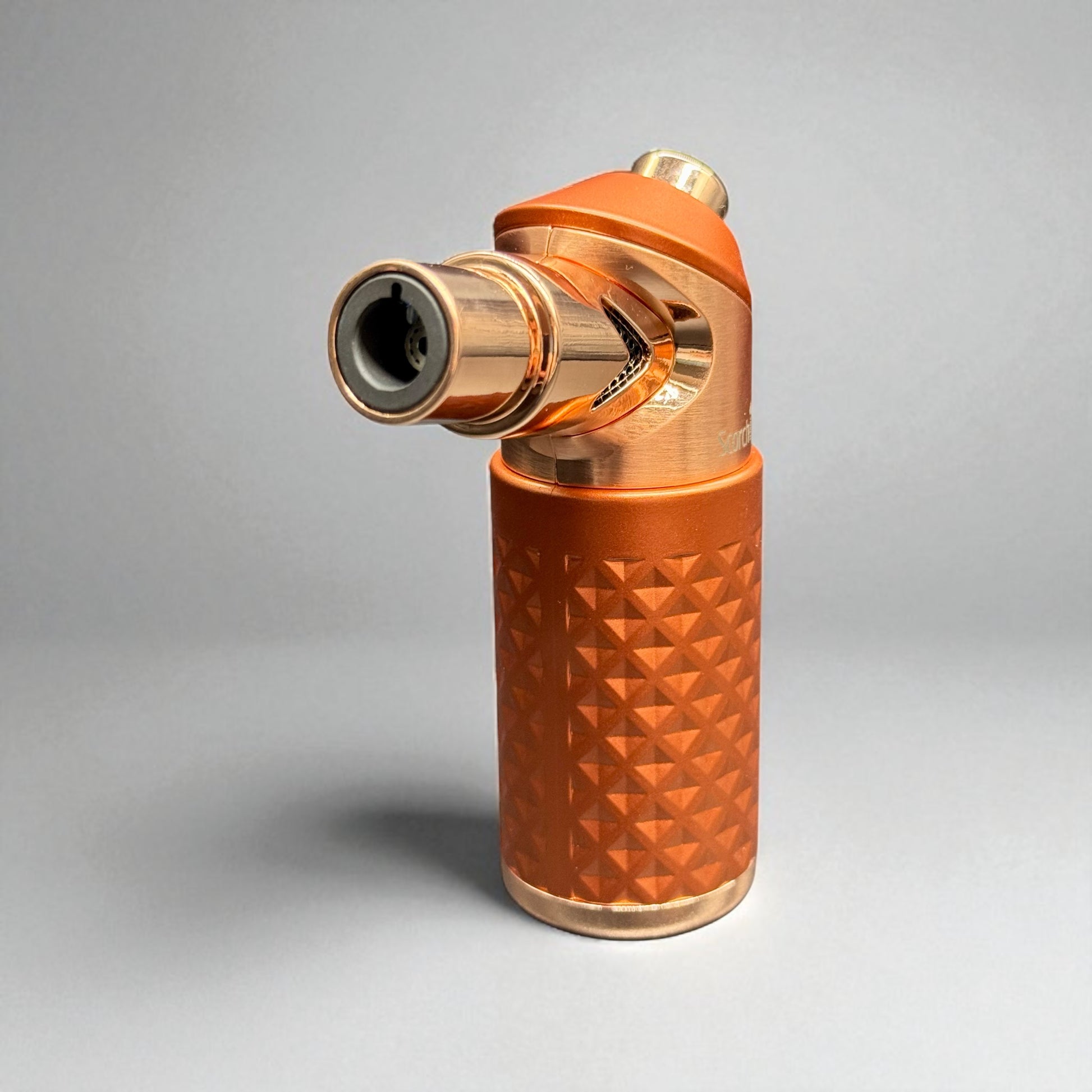 Copper-colored lighter with geometric design on a gray background