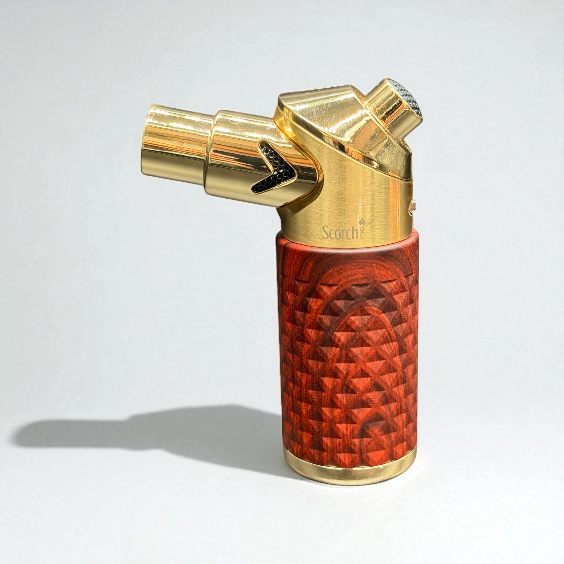 Gold and red lighter with geometric pattern on a white background