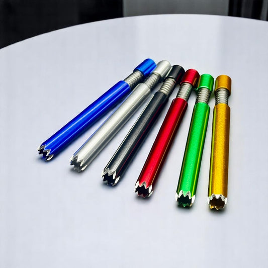 Six metallic pencil-shaped tools in blue, silver, black, red, green, and gold, arranged diagonally on a white surface.