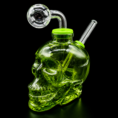 Green glass skull-shaped water pipe with a green cap on a black background