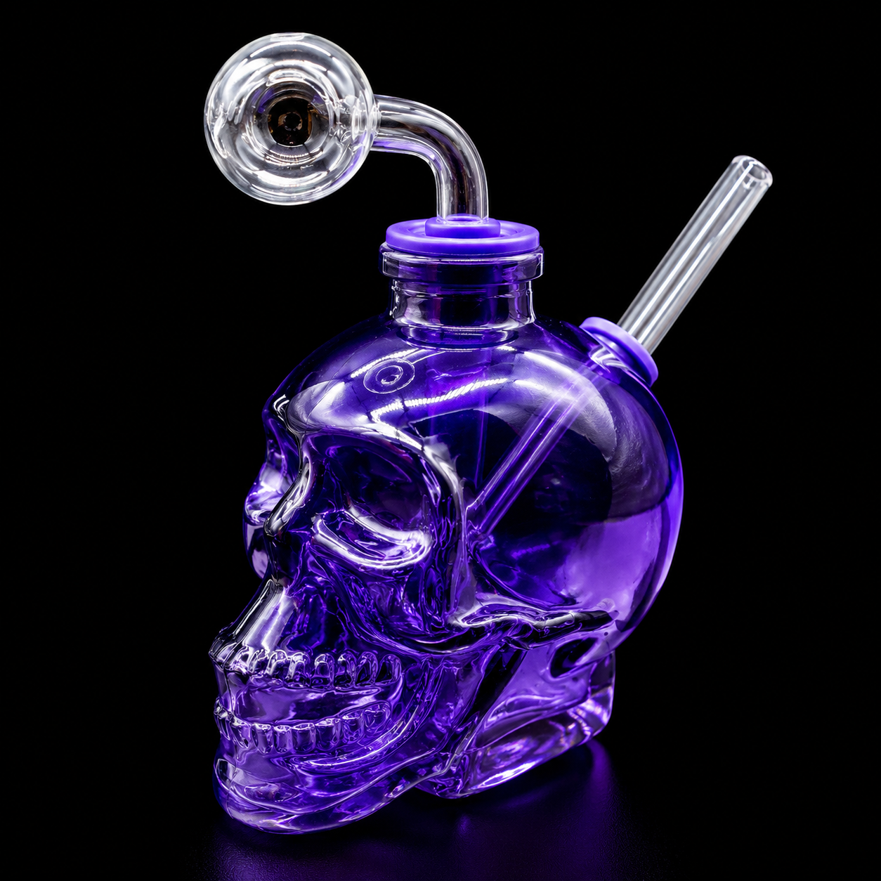 Purple glass skull-shaped water pipe with smoking attachments on a black background