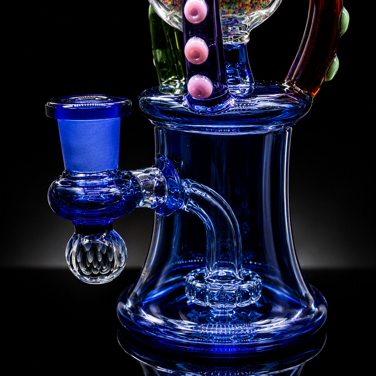 Glass water pipe with blue and clear components on a black background