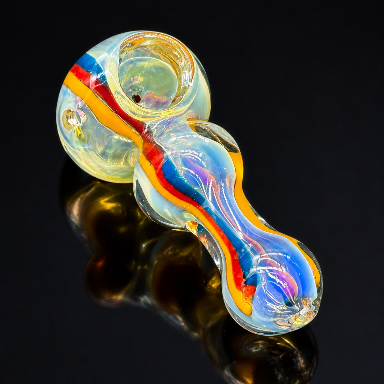 Colorful glass pipe on a reflective black surface