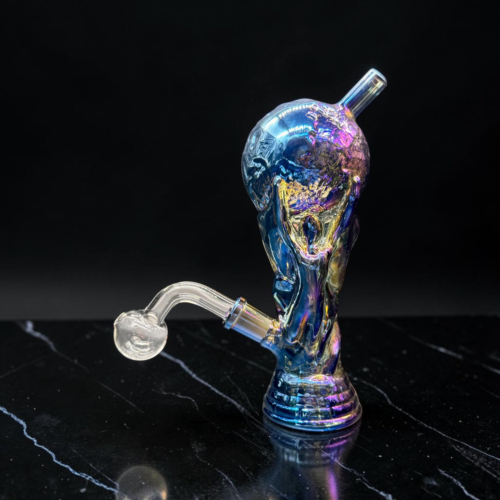 Multicolored glass smoking accessory on a black surface with a dark background