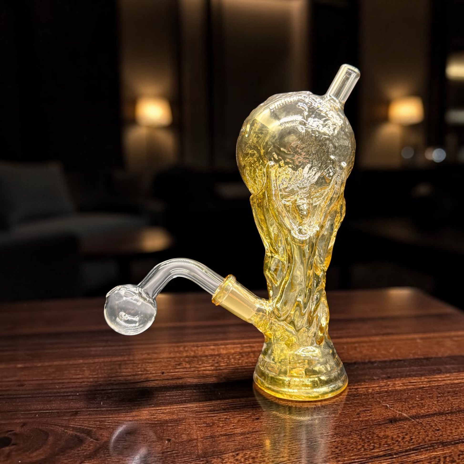 Glass smoking device on a wooden surface with a blurred background