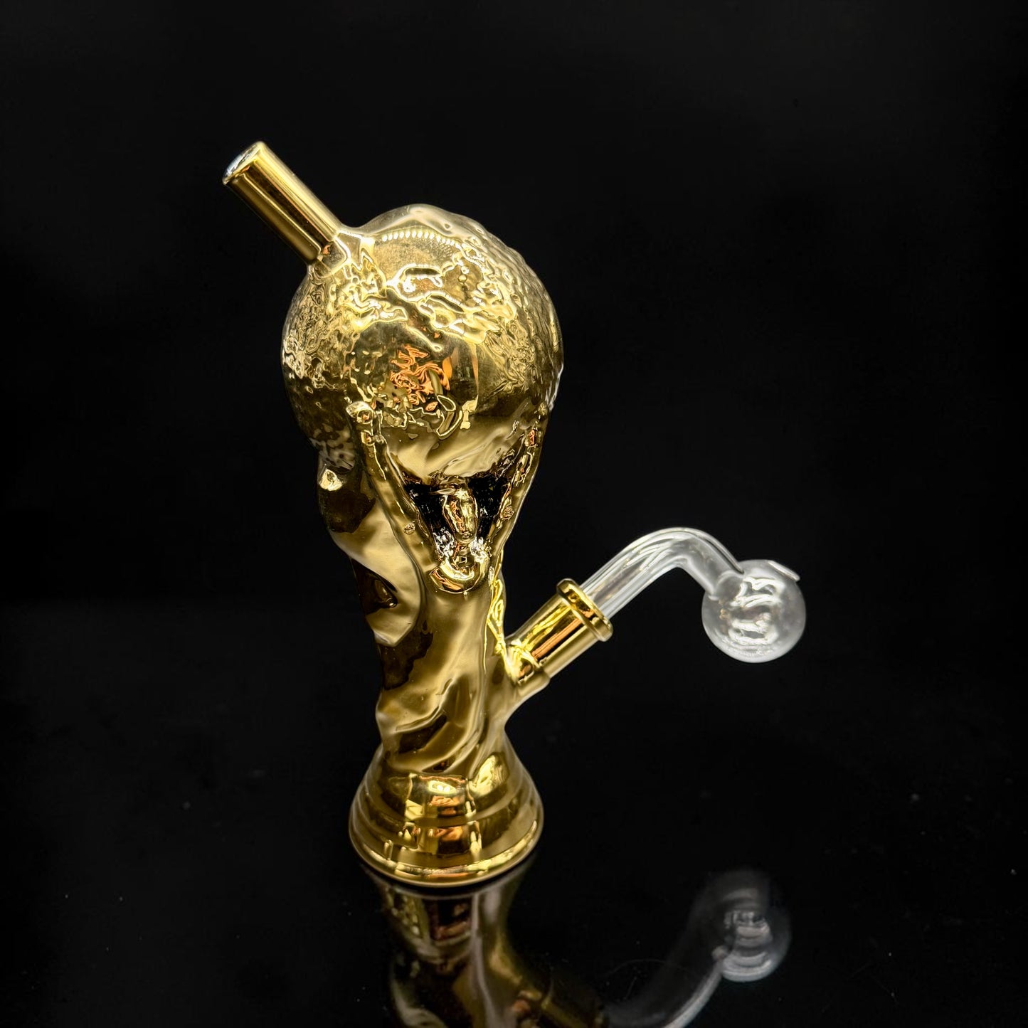 Gold-colored smoking accessory with a clear hose on a black background