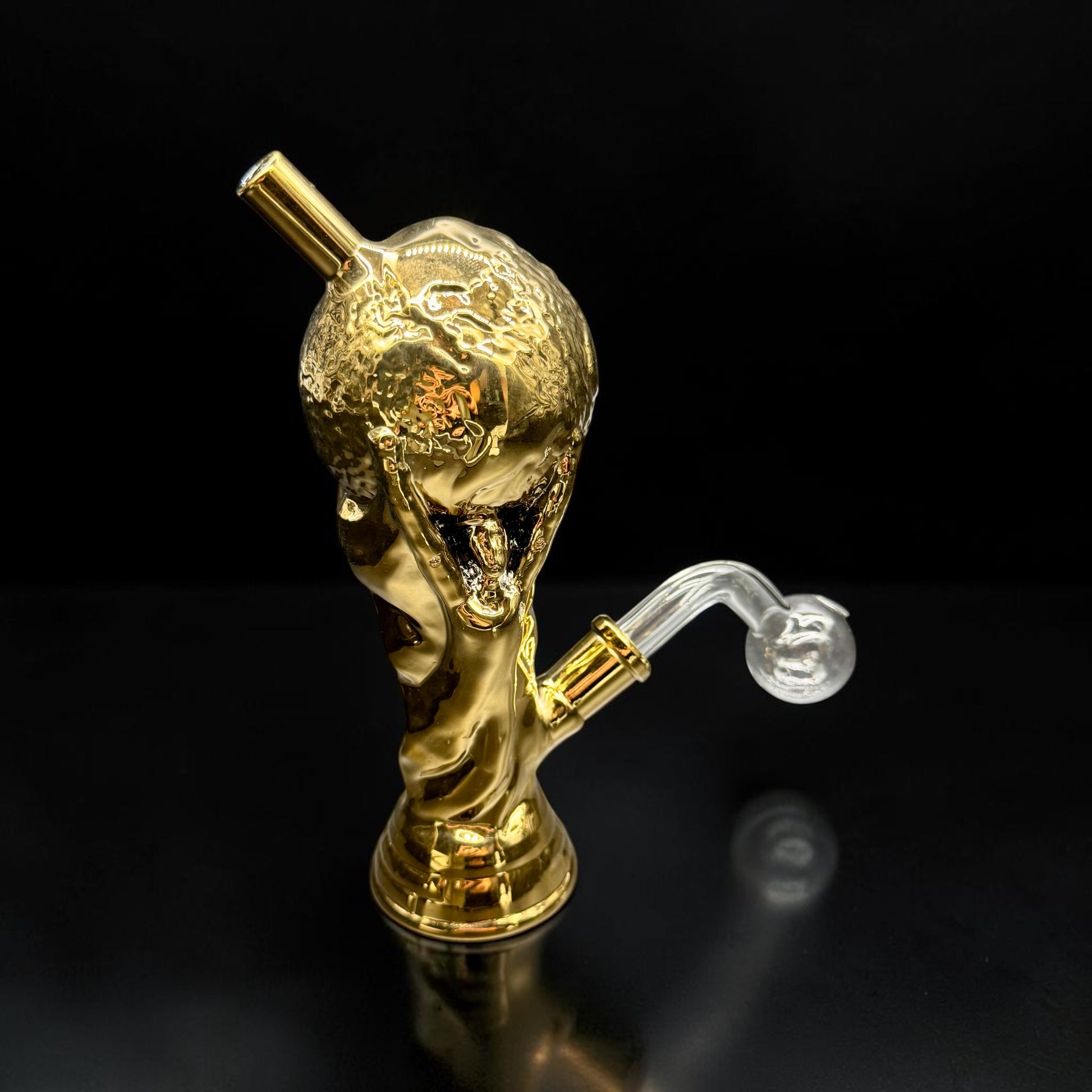 Gold smoking accessory with a clear chamber on a black background