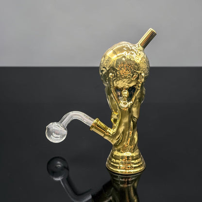 Gold-colored smoking accessory with a reflective surface on a gradient background