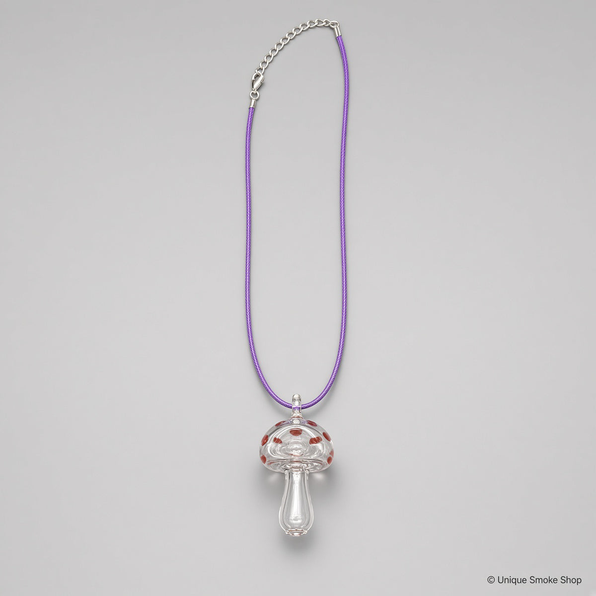 Mini hand-blown clear mushroom shaped glass pipe necklace with red dots on purple cord