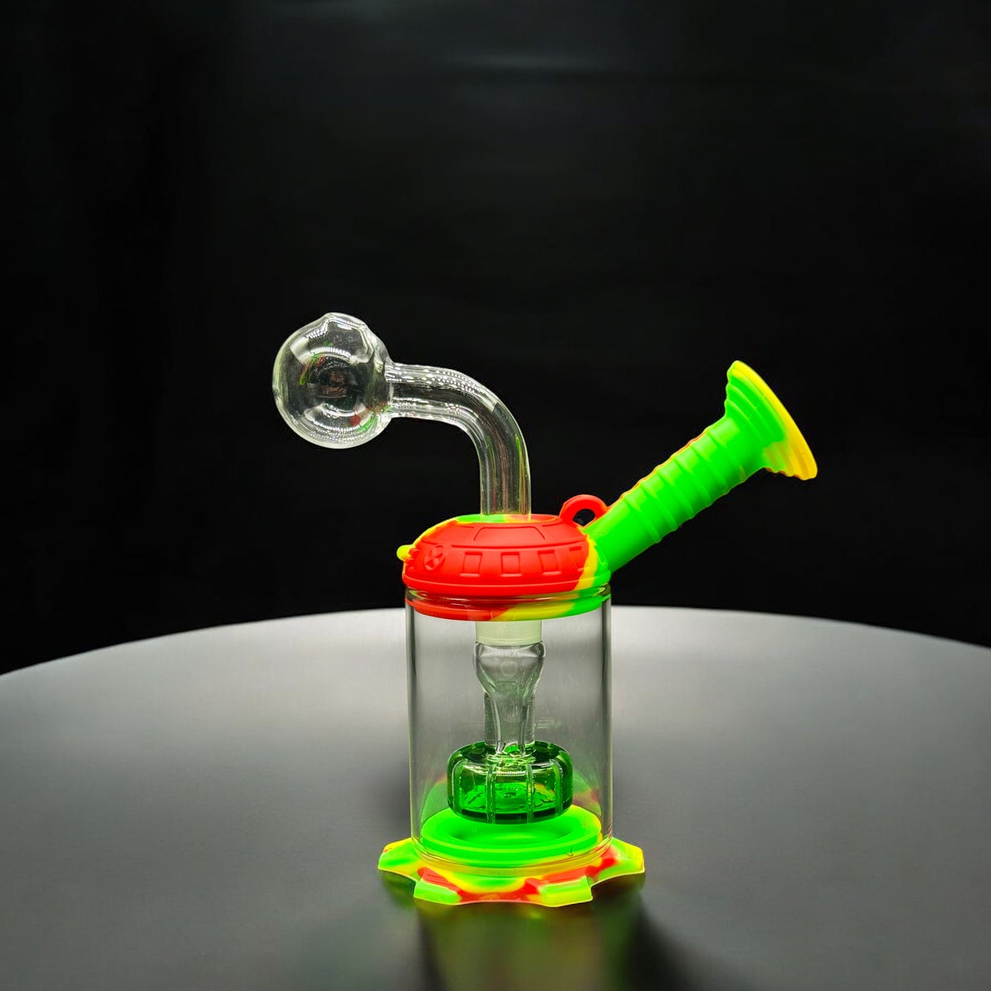 Rasta-colored mini silicone and glass water pipe with red, yellow, and green silicone base and handle