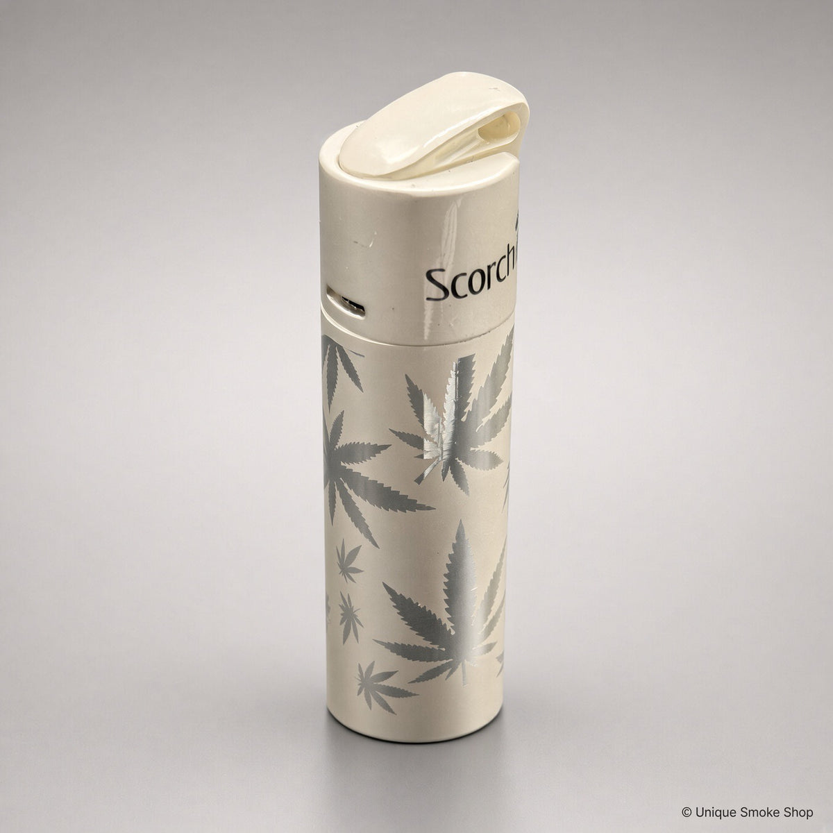 Scorch Torch 61838 cream metal single-flame lighter with cannabis leaf pattern, top lid view, 3 inches tall.