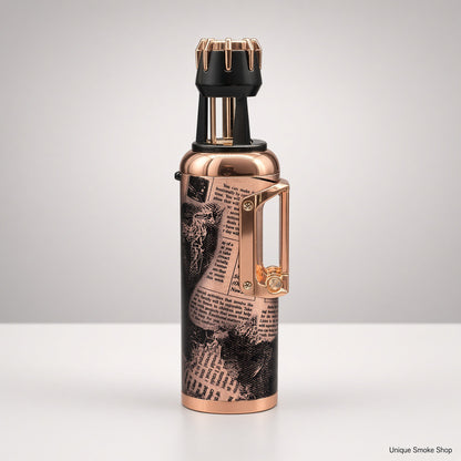 A metallic copper vape device with a black and white newspaper print graphic on the body, a black mouthpiece with gold accents, and a gold side clip, shown on a light gray background.