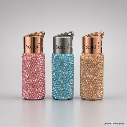 Scorch 61892 rhinestone single flame torch lighters in pink, teal, and champagne on a light gray studio background