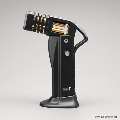 Black Scorch Torch Lighter with gold accents, side view on base – Unique Smoke Shop