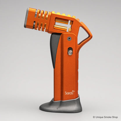 Orange Scorch Torch Lighter with gold internals, side view on base – Unique Smoke Shop